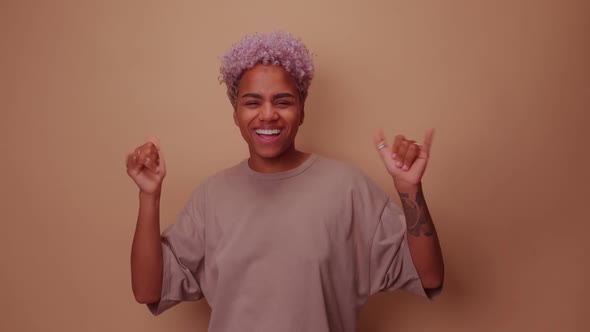 Friendly Looking Positive African American Woman Shows Shaka Sign Gestures