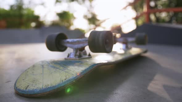 Closeup Shot of Skateboard on the Ground in Sun Beams