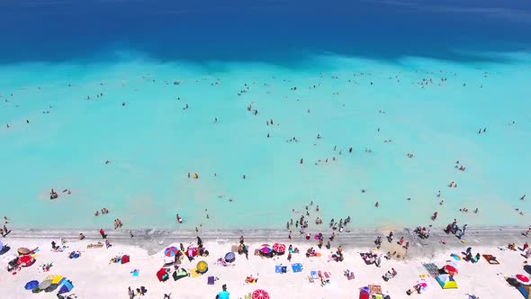 People Swim on Vacation in the White Sandy Beach of the Clear Tropical Turquoise Light Blue Sea