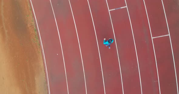 Cinematic Shot of Young Arab Sportswoman with Athletic Body in Hijab Running with Effort and