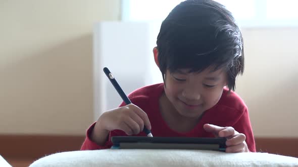 Asian Child Drawing Picture With Digital Pen On Tablet Pc Computer