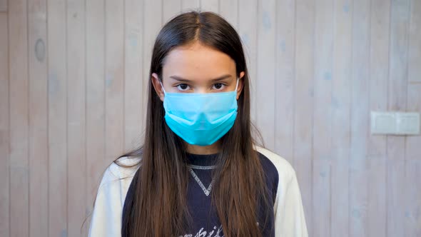 Teenage Girl Wearing Medical Protective Facemask Looking at Camera. Covid-19, Coronavirus Outbreak