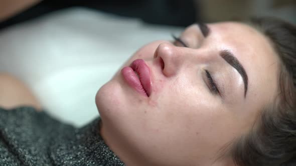 High Angle View Face of Young Slim Woman in Beauty Salon with Beautician Removing Blood and Red