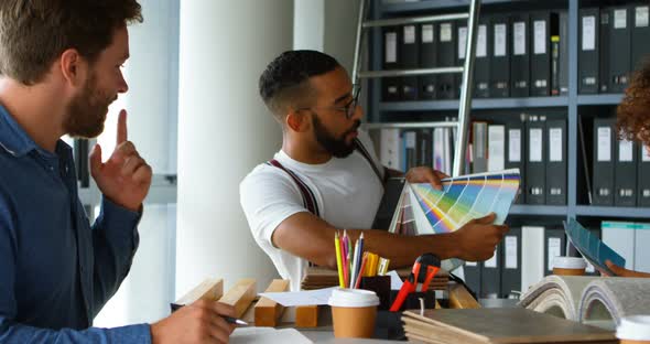 Business Colleagues Discussing Over Color Swatch at Desk