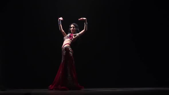 Exotic Belly Dancer Woman in Chiffon Dress. Black Background. Slow Motion