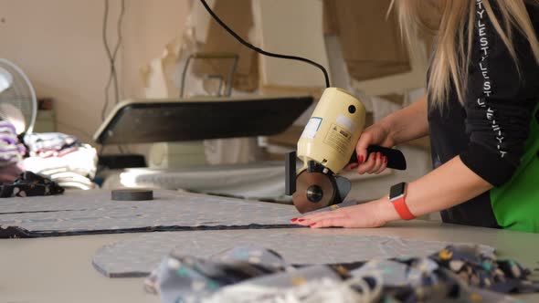 Female Using Electric Cutting Fabric Machine