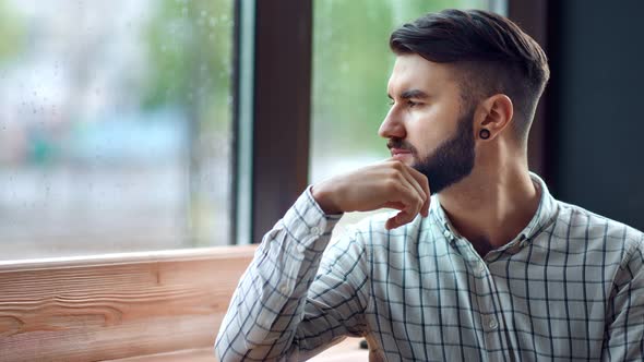 Sad Lonely Fashion Man Boring Looking Out of Window at Rainy Day Feeling Depressed Medium Closeup