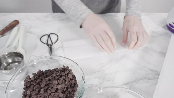 Step by step. Ingredients to prepare chocolate dipped strawberries on a marble surface.