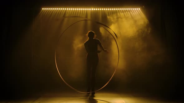 Cute Girl Gymnast Makes Performs Beautiful Circular Movements with a Ribbon. Shot in Dark Studio