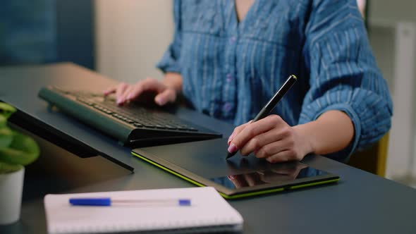 Close Up of Hands Using Graphic Tablet with Stylus and Keyboard