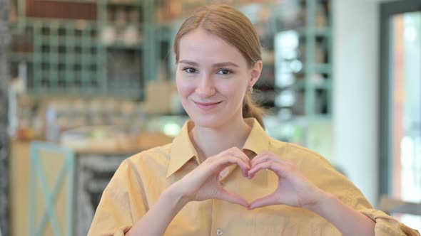 Portrait of Young Woman Making Heart Shape