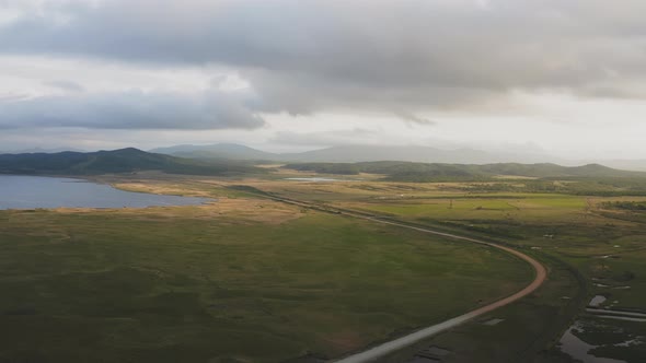 Drone View of a Sunset in a Valley with a River and Mountain Ranges