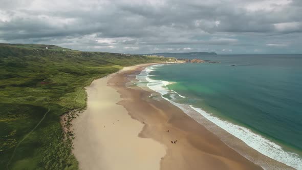 Timelapse Ireland Sand Beach Aerial View: Ocean Waves, Sandy Coastline, White Shore, Greenery Meadow
