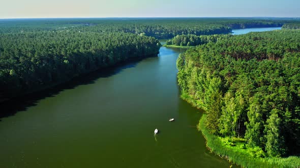 Small fishing boat on a large lake between forests