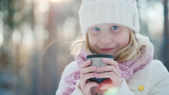 A 6 Year Old Girl Drinks Hot Tea on the Street