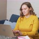 Woman in Yellow Sweater is Sitting at Desk and Working on Laptop - VideoHive Item for Sale