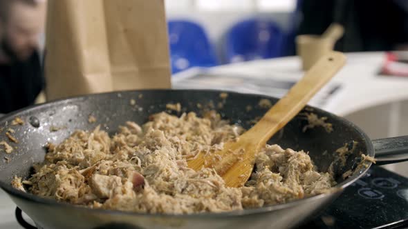 Slow Motion of Middle Aged Chef Mixing Salsa of Fried Meat Fillet with Wooden Spoon in a Pan in a