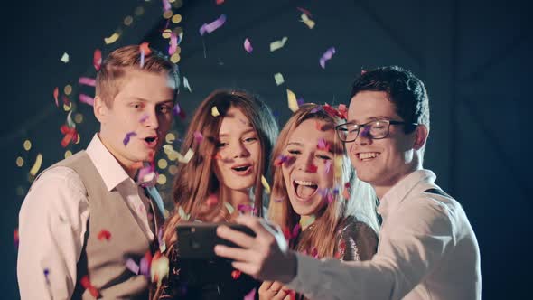 Smiling Multiracial Friends Throw Confetti Posing and Taking Selfie on Smartphone or Mobile Phone