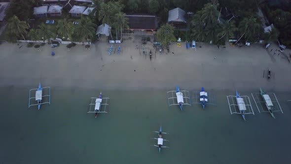 Aerial view of fishing village by the beach early morning in the Philippines - camera pedestal up ti