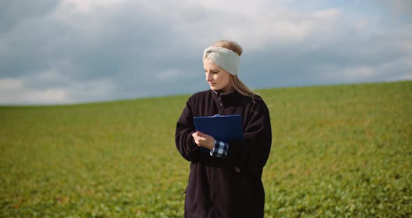 Female Farmer Examining Oilseed Rape Field