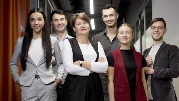 Middle Shot of Confident Smiling Caucasian Men and Women Standing in Office Corridor Looking at