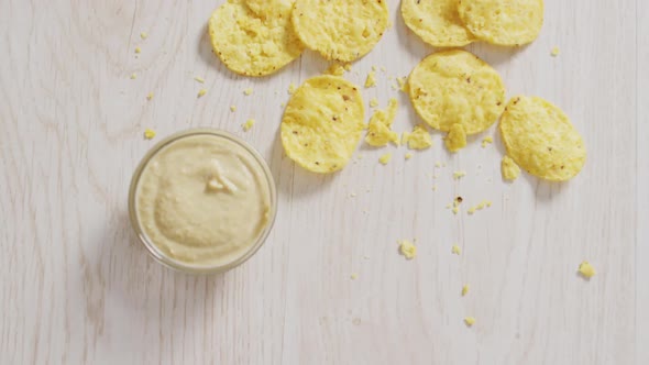 Video of crisps and cheese dip on a wooden surface