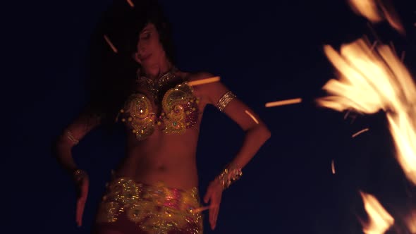 Girl in Beautiful Clothes Dancing Belly Dance, Near the Fire