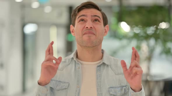Portrait of Creative Young Man Praying Fingers Crossed alt