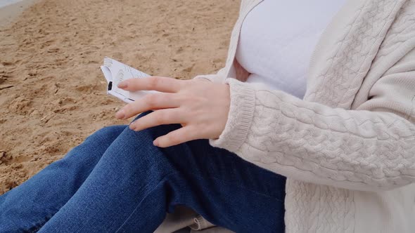 Young Redhaired Woman Reading Magazine on Beach