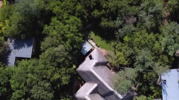 Aerial top spinning Shot over accommodation surrounded by lush green vegetation outside Kruger Natio