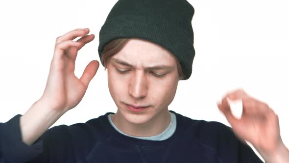 Portrait of Blueeyed Attractive Teen Guy Wearing Sweatshirt Fixing His Hat on Camera Isolated Over