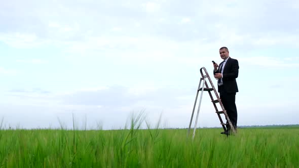 Young Businessman in the Middle of the Field Looking for Internet Connection