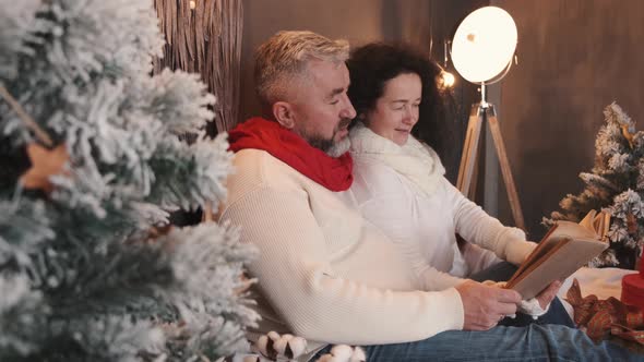 Senior Couple Reading and Relaxing on the Bed in Christmas Atmosphere