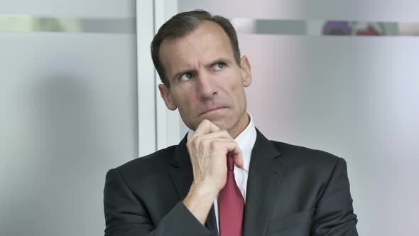 Thinking Middle Aged Businessman in Office