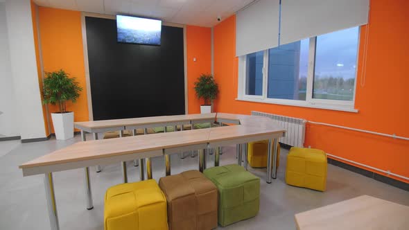 Place to Rest with Tables Poufs and TV Set in Coworking Room