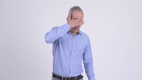 Stressed Persian Businessman Covering Eyes Against White Background