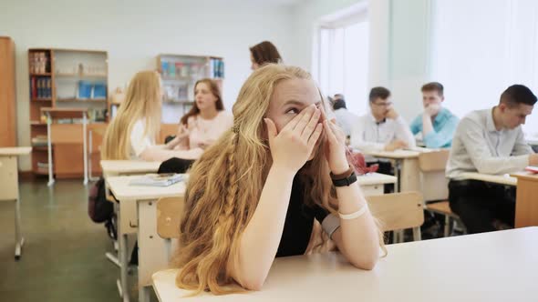 The Girl is a Schoolgirl Crying in Class and Her Classmates Console Her