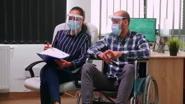 Disabled Man and Partner with Masks Having Videomeeting