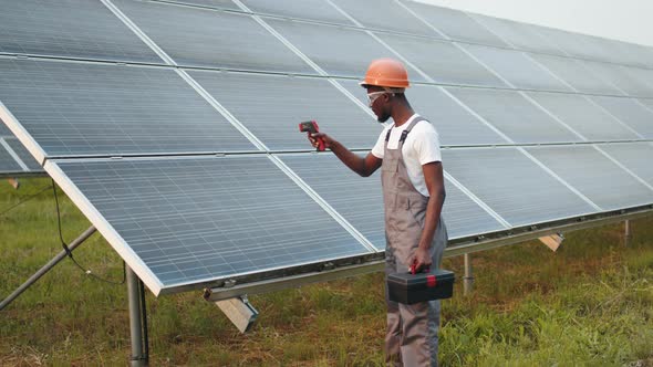 African American Engineer in Uniform Safety Helmet and Glasses Using Thermal