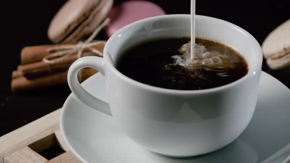 Closeup of Pouring Fresh Milk in Cup of Coffee