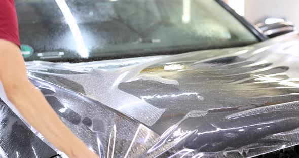 Man Repairman Wrapping Protective Vinyl Film Over Car  Movie