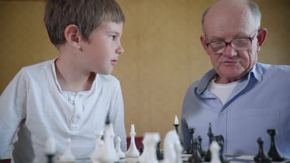 Family Recreation, Simpatic Joyful Boy Playing with His Elderly Grandfather in Glasses for Sight