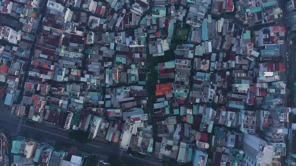 early morning top down drone view of streets and rooftops in a busy and densely populated area featu