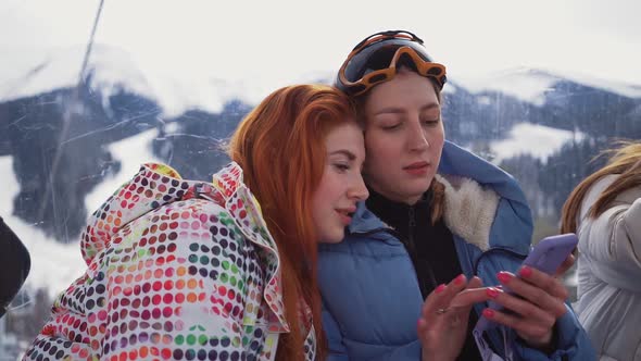 Two Lesbian Women Sit Hugging in Lift Up Mountain