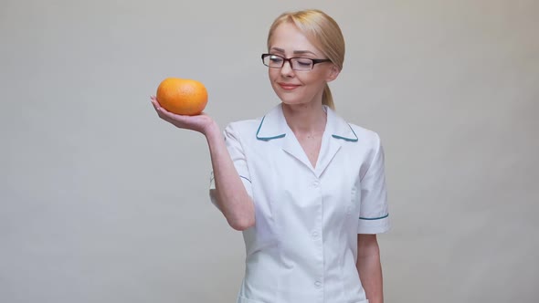 Nutritionist Doctor Healthy Lifestyle Concept - Holding Organic Grapefruit Fruit and Alarm Clock