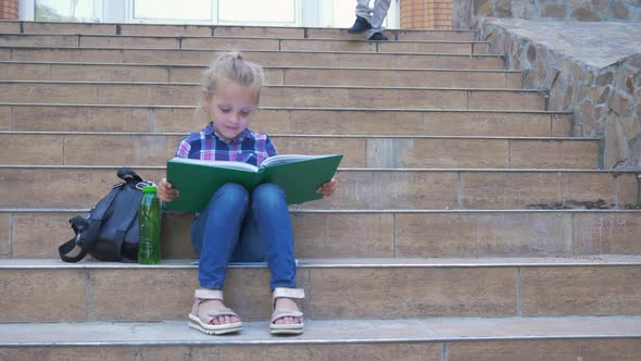 School Recess, Female Pupil Reading a Book Sitting on Steps with Backpack, Boy Classmate Running To