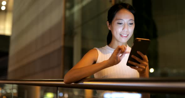 Woman sending text message on cellphone in city 