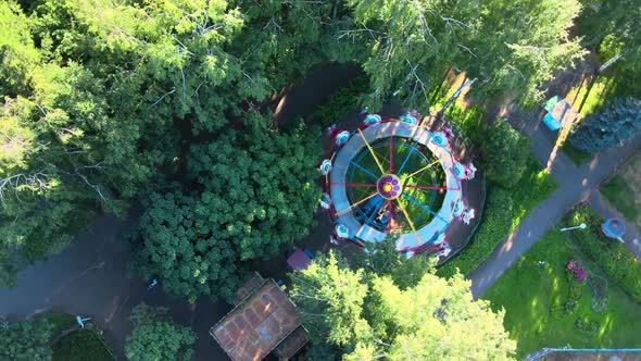 Bright carousel in city park. Extreme recreation for people on sunny summer day.