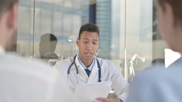 Rear Back View of Couple Getting Report Result From Young Doctor 