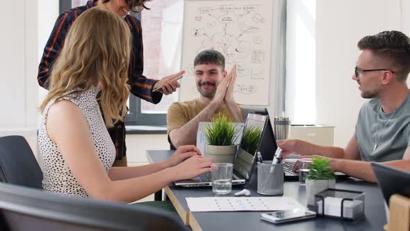 Woman Showing Smartphone To Colleagues at Office